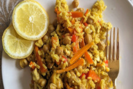 Rice Vegetable Pilaf, garnished with fresh lemon pieces, neatly arranged on a white plate.