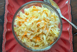 A sauerkraut salad, served in a red bowl.