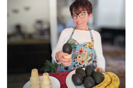 woman holding an ice cream cone with a whole avocado inside